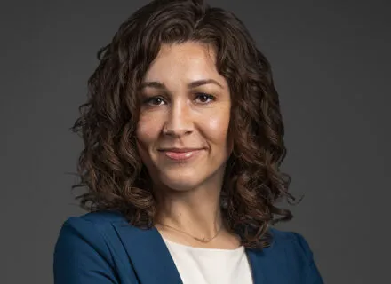 michelle ryland, brunette, blue blazer, olive complexion, smirking at camera with arms crossed, white top