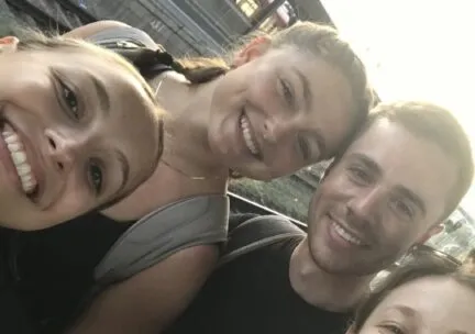 a picture of four alumns smiling at the camera