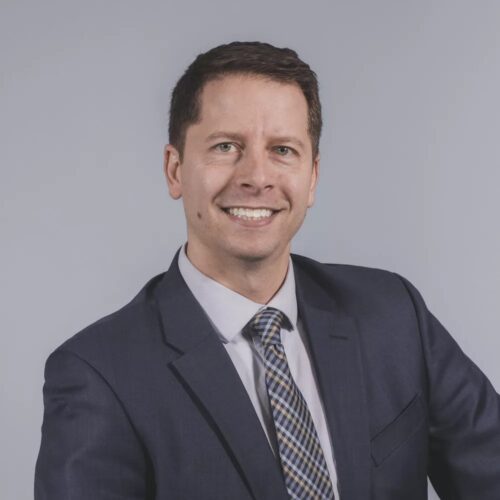 Matt streid, smiling at camera, blue blazer, purplish shirt, short cropped hair, white complexion