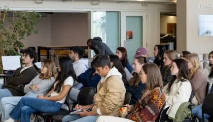 students sitting in chairs in atrium
