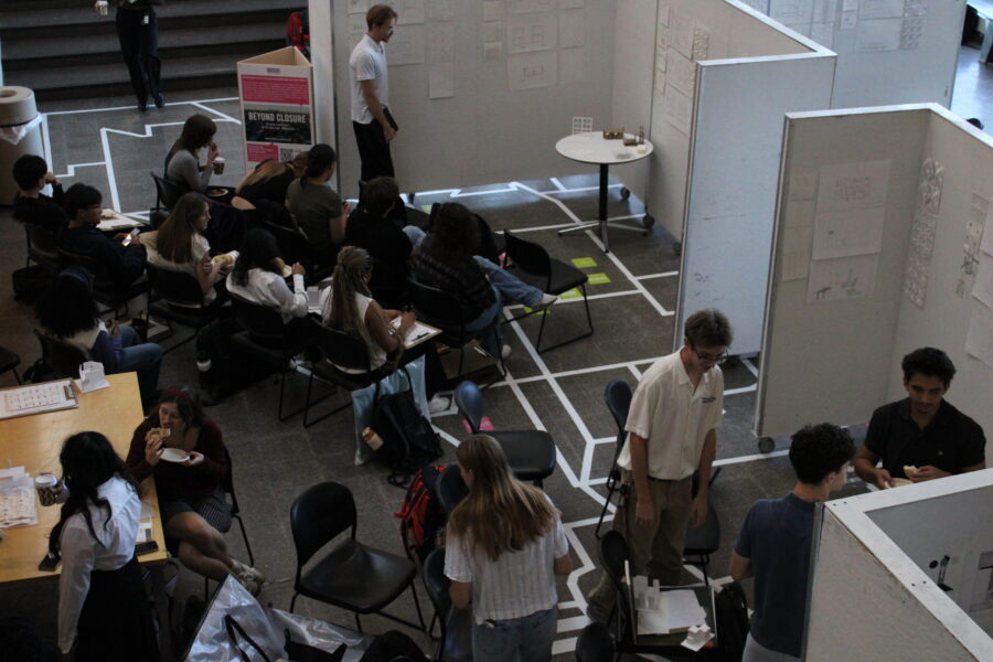 students presenting projects in front of white walls