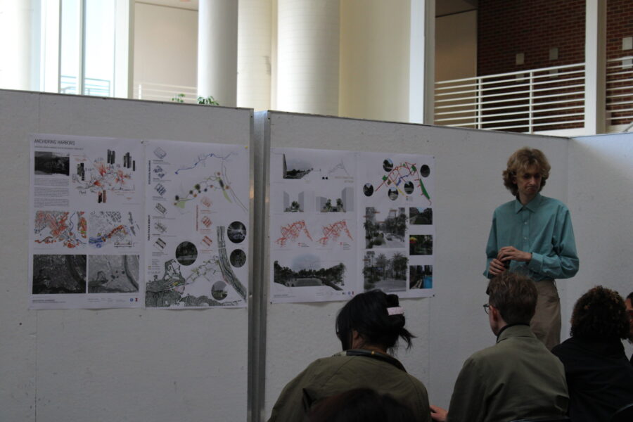 a student presenting posters in front of an audience
