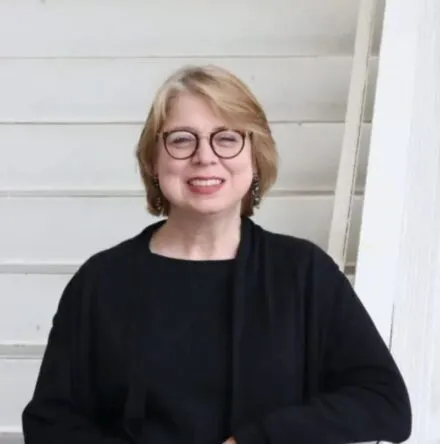 Caucasian lady with Blond colored hair in black top 
