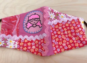 Mask with pink patterns and person with long pink hair