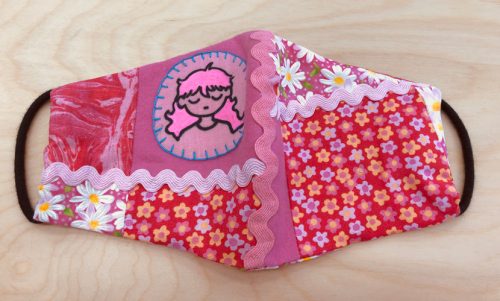 Mask with pink patterns and person with long pink hair