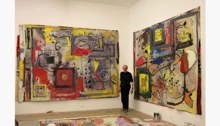 Tom Goldenberg with two paintings in his studio