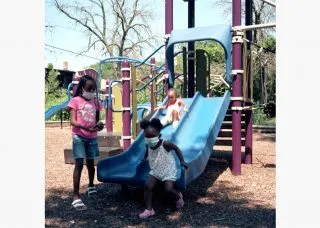 Children wearing masks near playground equipment