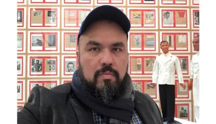 Jorge Lucero in front of art exhibit