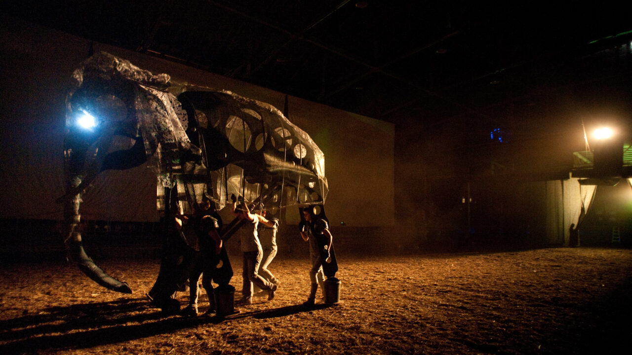 Performance view of the Unreliable Bestiary showing projection, performers, and audience