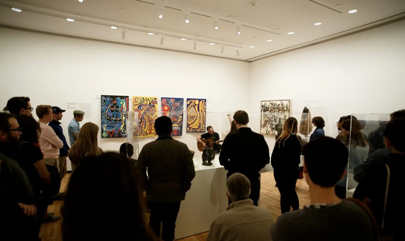 Photo of students and faculty engaged in critique in a gallery