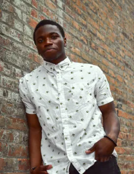 A 1/2-length portrait of the student leaning against a wall