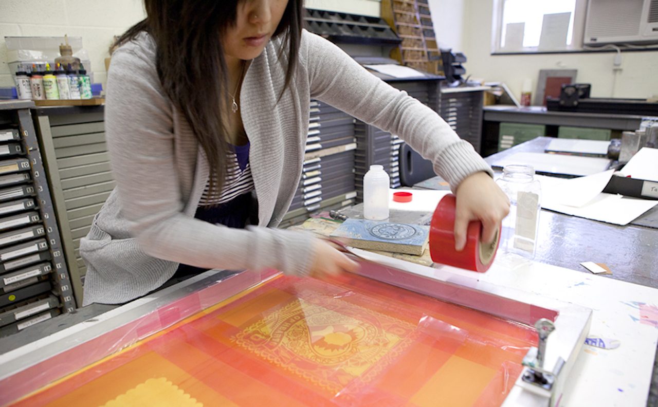 Photo of a student printing from a silkscreen