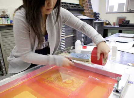 Photo of a student making a silkscreen print
