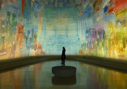 Photo of figure standing in a large curved mural