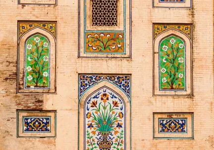 Photo of colorful mosaics set into an architectural façade.