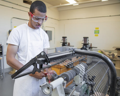 student using a lathe in the woodshop