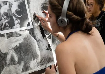 Photo of a student working on a charcoal drawing