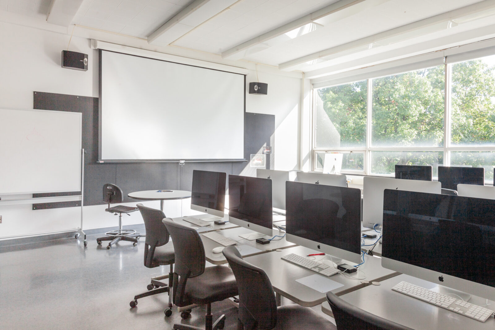 row of computers in a brightly lit classroom