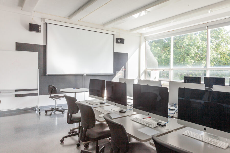 row of computers in a brightly lit classroom