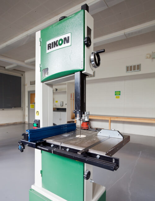 a green bandsaw in a woodshop