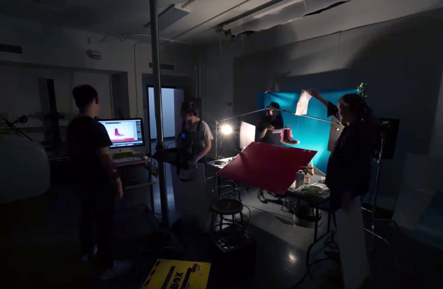 students work in a dark photography studio with a camera and computer