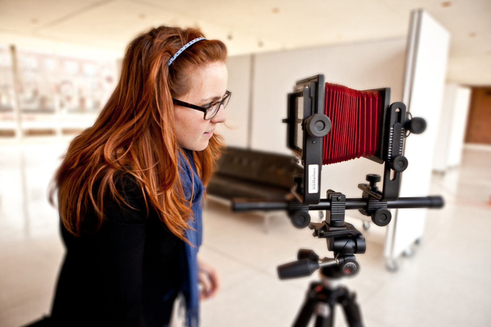 student looks through viewfinder of 4x5 film camera