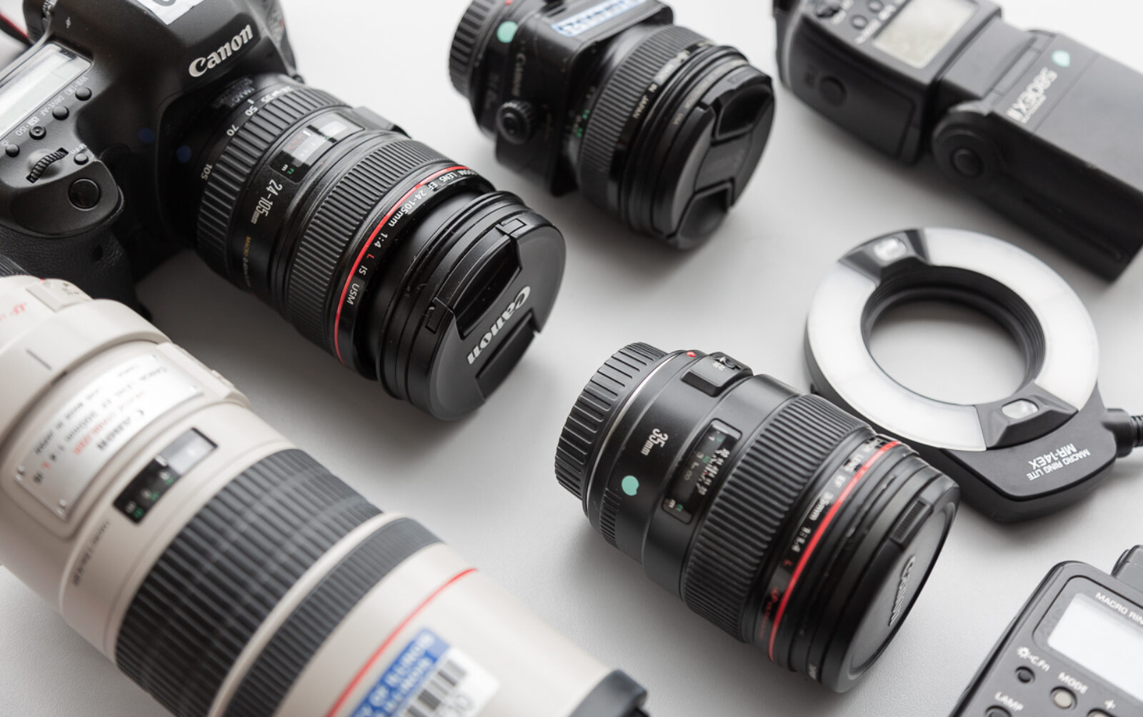 photograph of a canon camera and several lens on a gray table