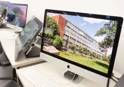 Photo of a row of imacs with the A&amp;D building on the desktop