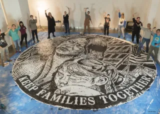 students around large medallion painted on floor