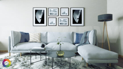 Digital image of a living room with a light blue sectional couch, two cofree tables, and a group of framed black and white photographs on the wall