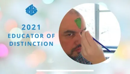 Jorge educator of distinction with someone painting green on his forehead