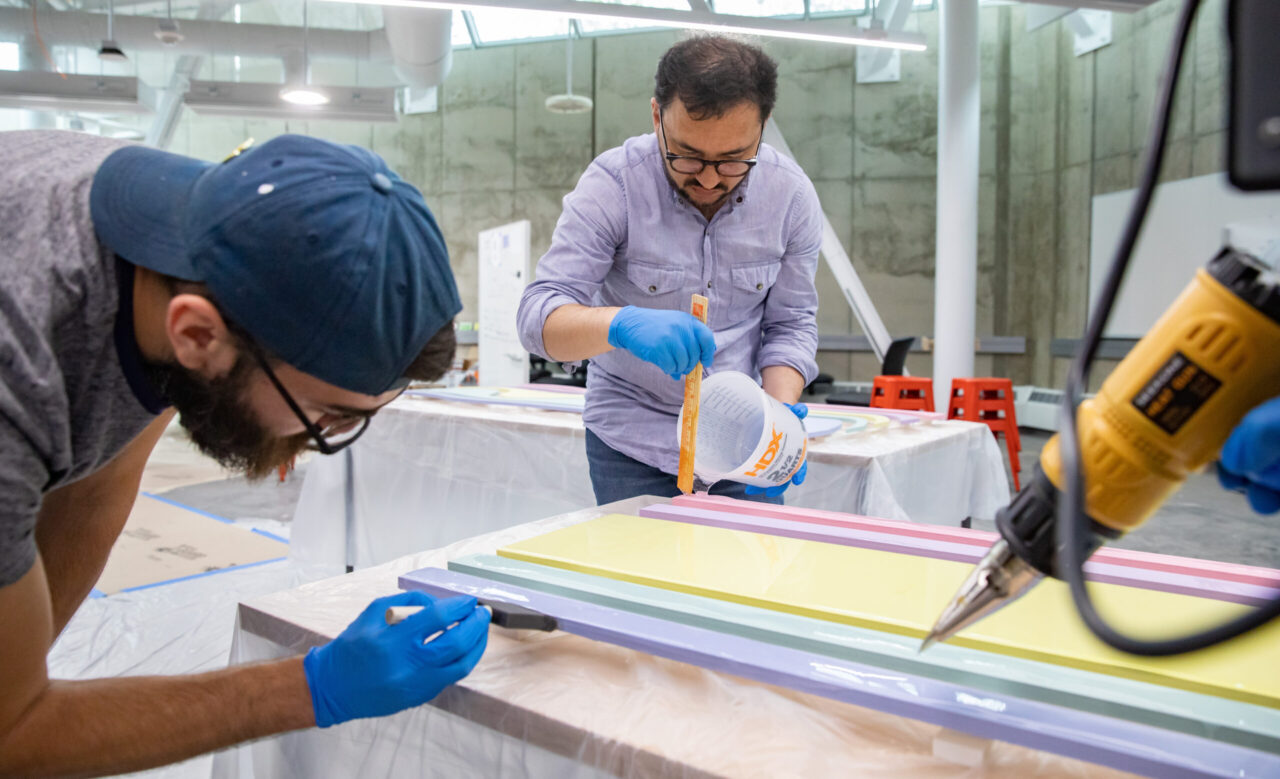 Juan and student working on mural