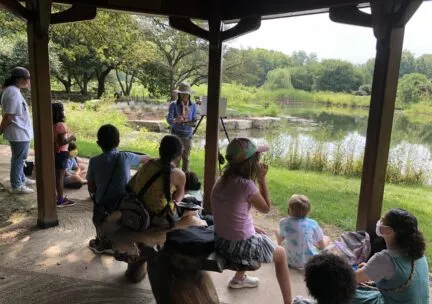 children watching a painting demonstration by an instructor at the Japan House