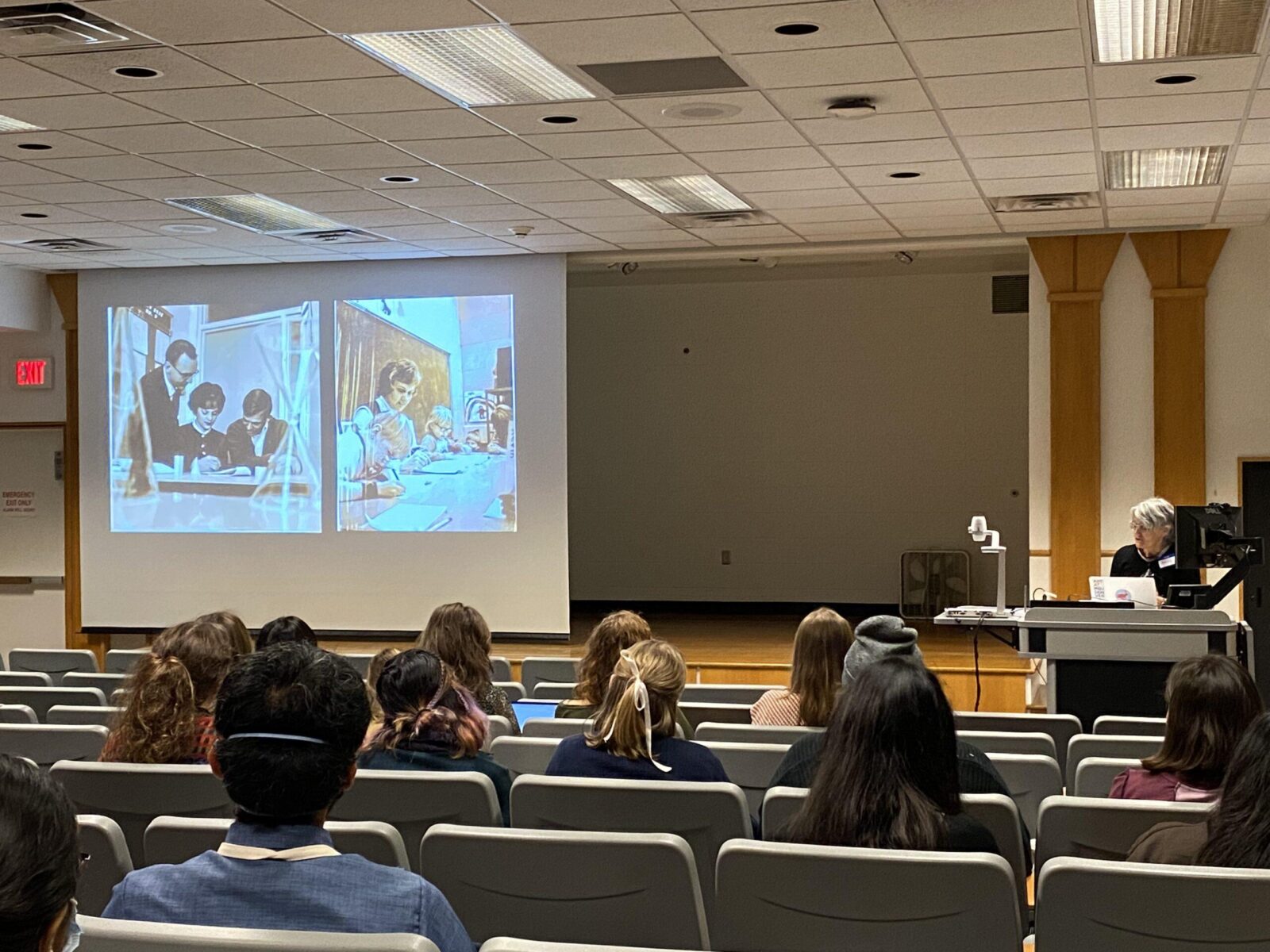 professor thulson lecturing with a picture of her parents