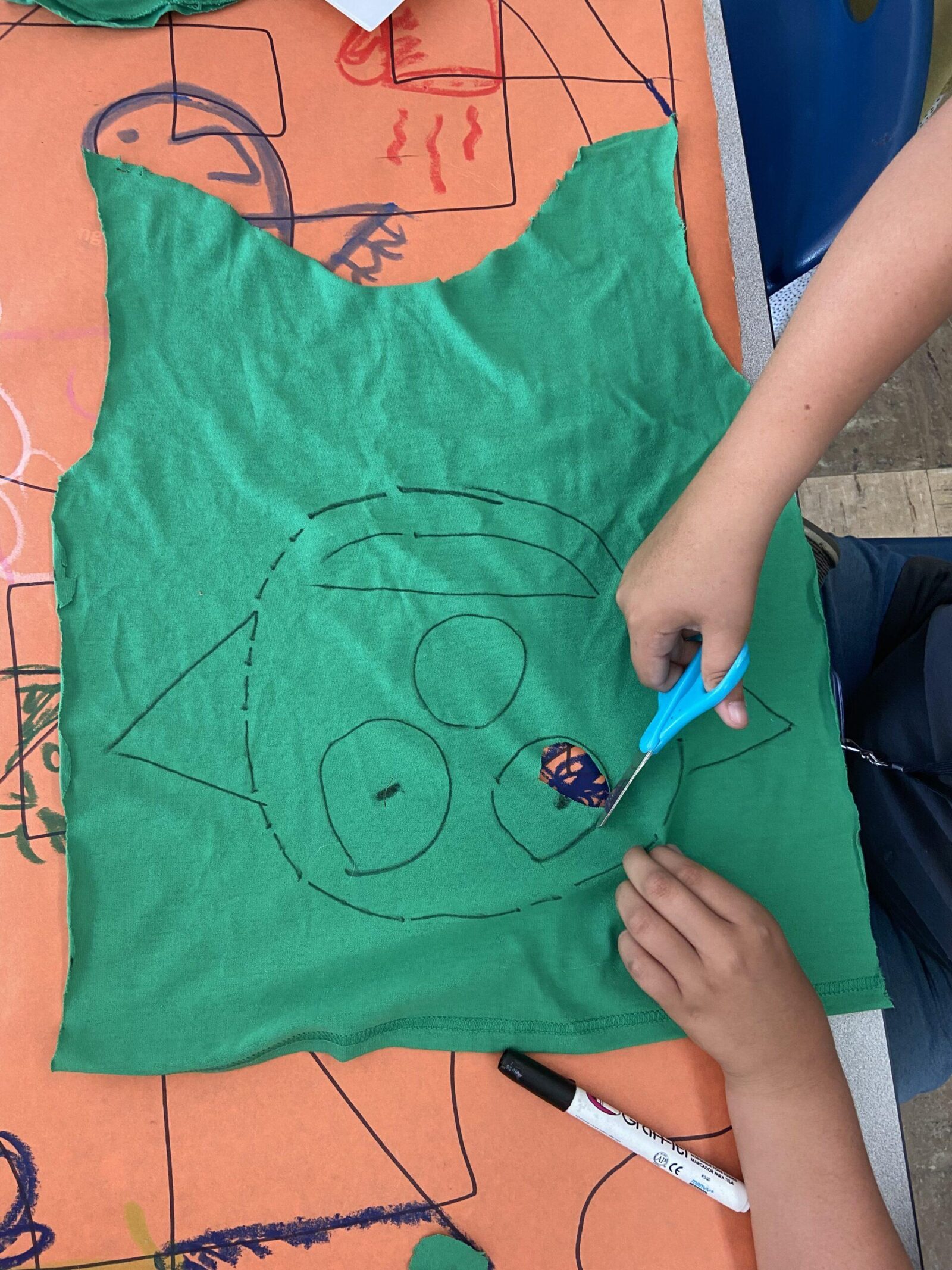 a child cutting a mask out of fabric