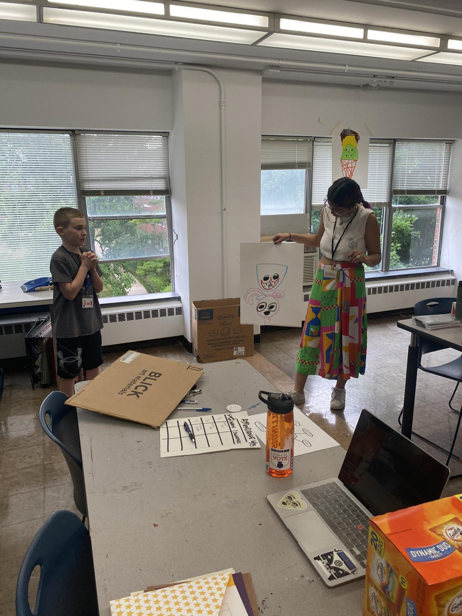 a teacher showing the class another students drawings