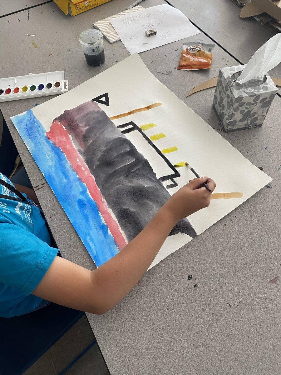 a child's hand painting a steamboat