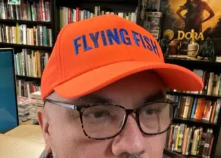 portrait of Lucero in his office wearing baseball cap