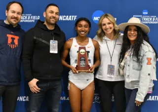 Olivia holding trophy surrounded by coaches and family