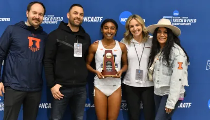 Olivia holding trophy surrounded by coaches and family