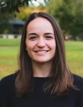 Portrait of the smiling student with a green landscape background