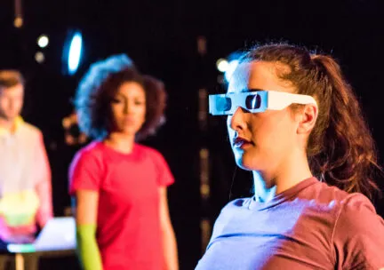 A dancer wears 3D glasses on stage