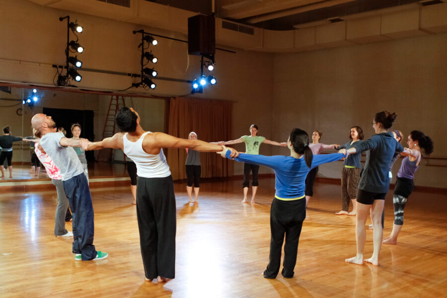 Sahar Izimi and students standing in circle and holding hands