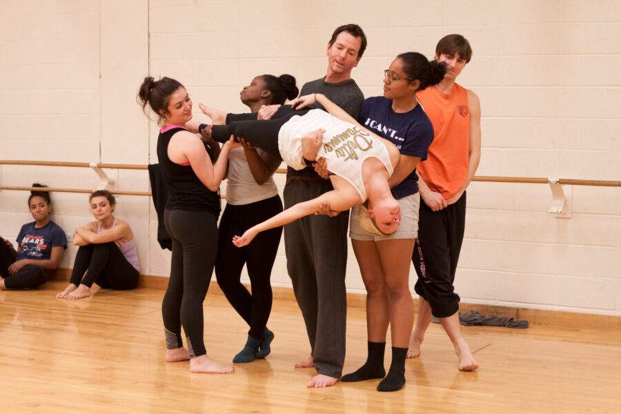 Sheldon Smith holding student in air with help of 4 students