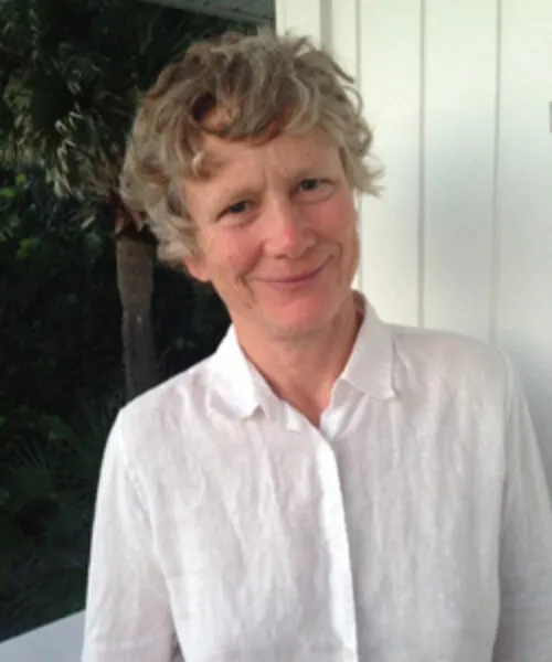 A headshot of Jennifer, wearing a white shirt and smiling