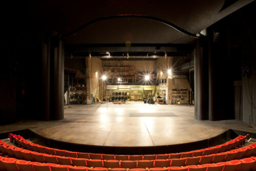 Proscenium stage with red seats, curtain open