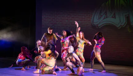 many people dressed in colorful costumes dance onstage