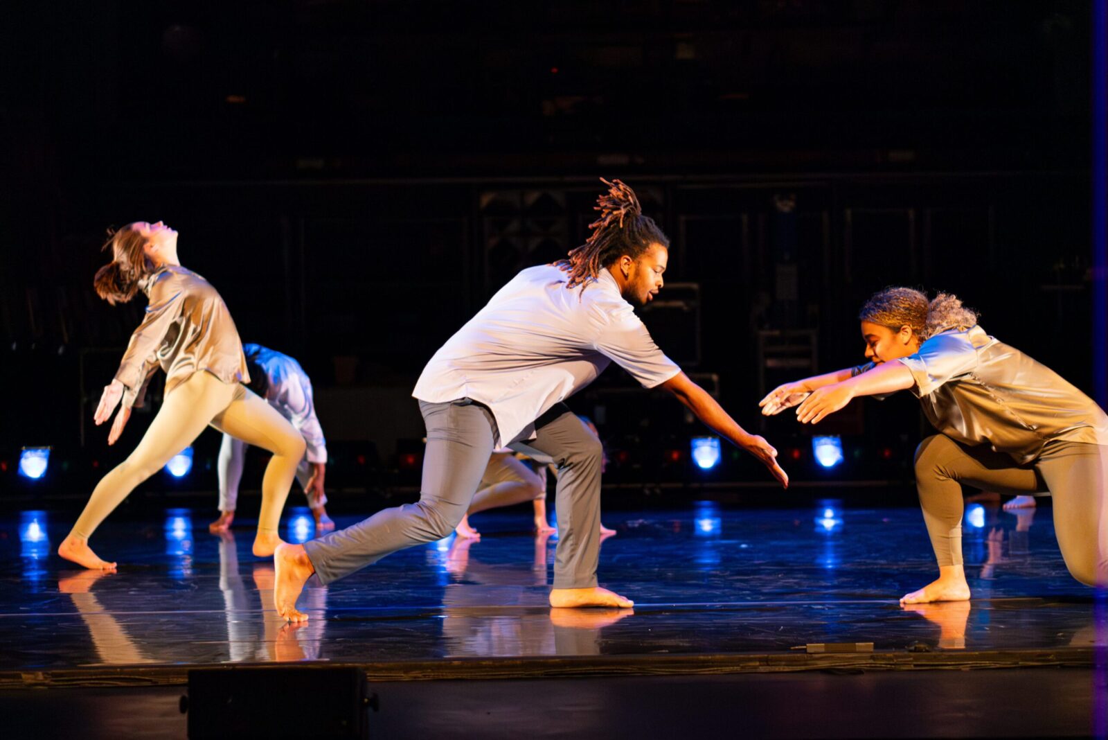 A dancer with outstretched arms reaches for another dancer