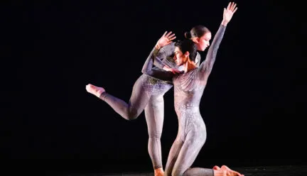 two people in leotards dance together onstage