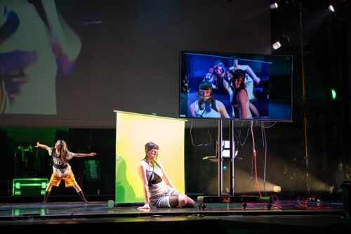 One dancers with her arm outstretched while two other dancers lean on her